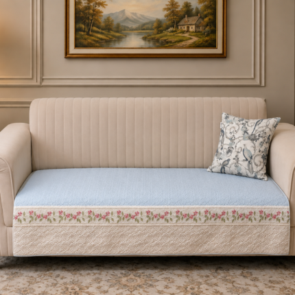 Soft blue quilting with delicate floral embroidery and an elegant handcrafted border